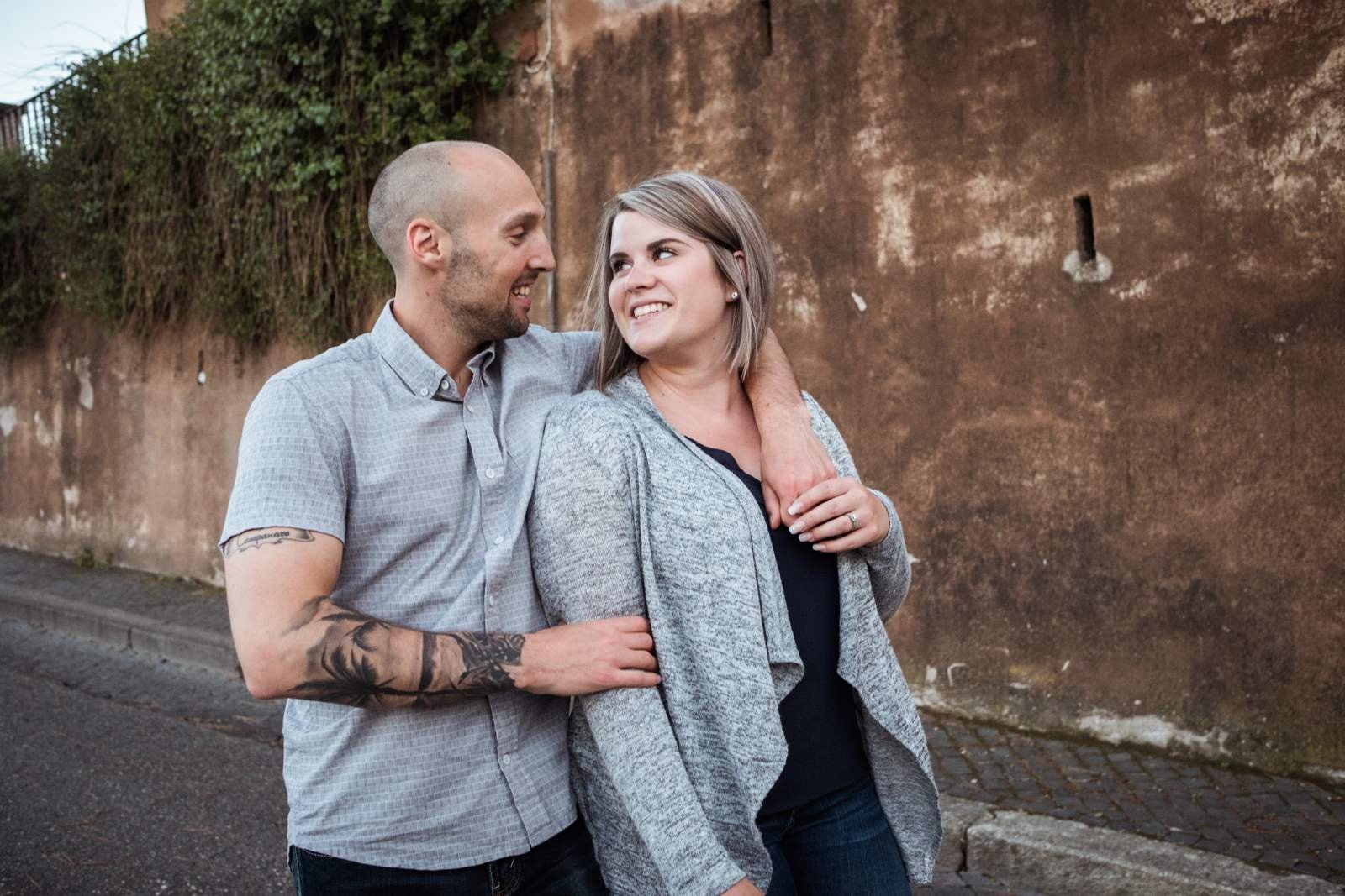 A couple leaning on an old Roman wall