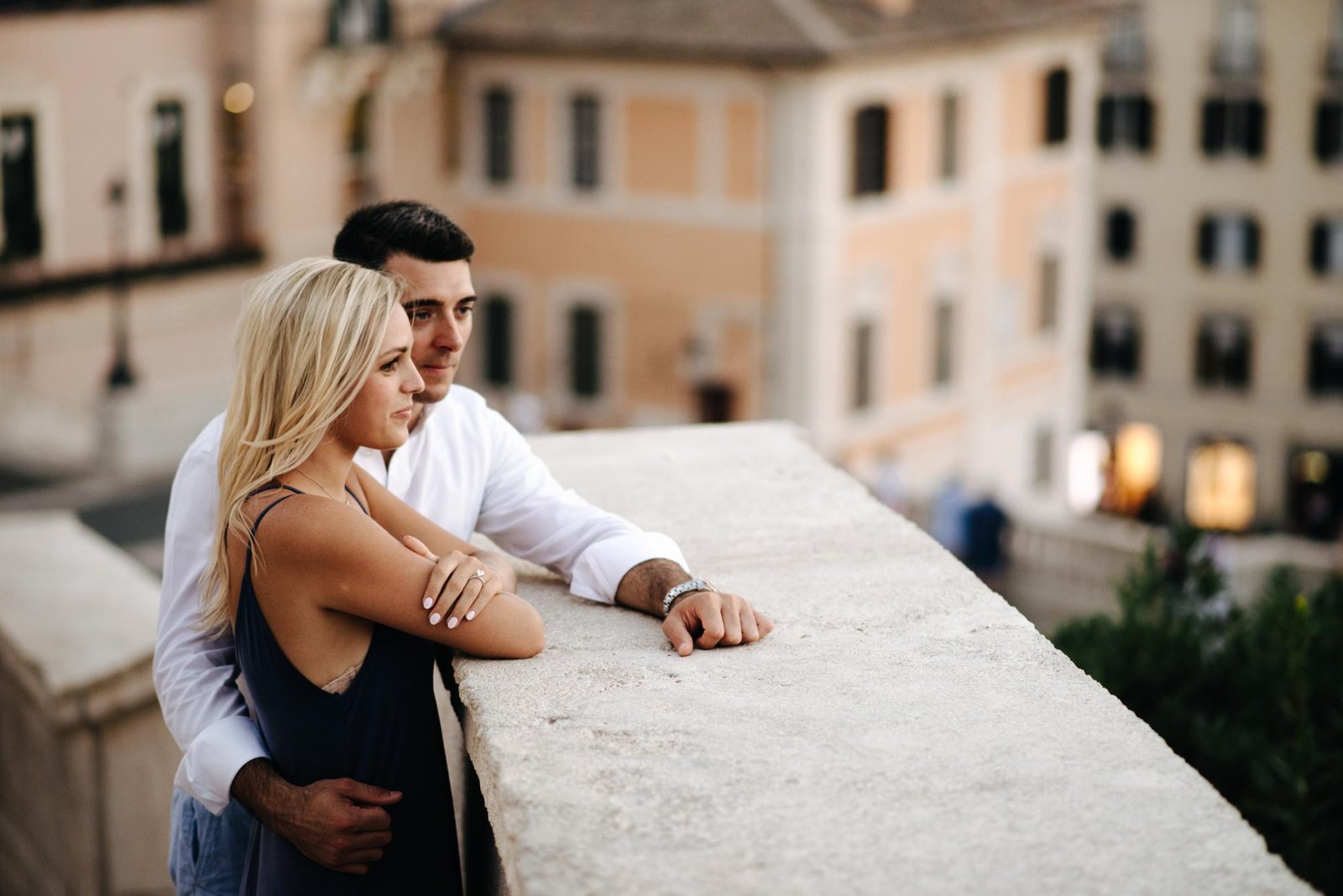 A couple laughing on a stone balcony