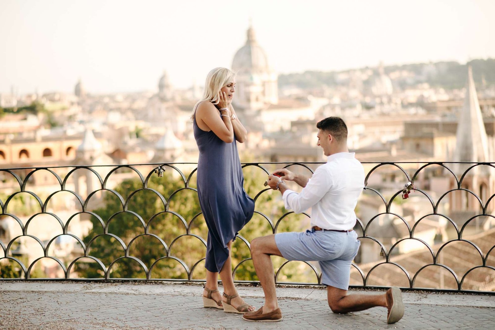 A man on one knee on a terrace above Rome