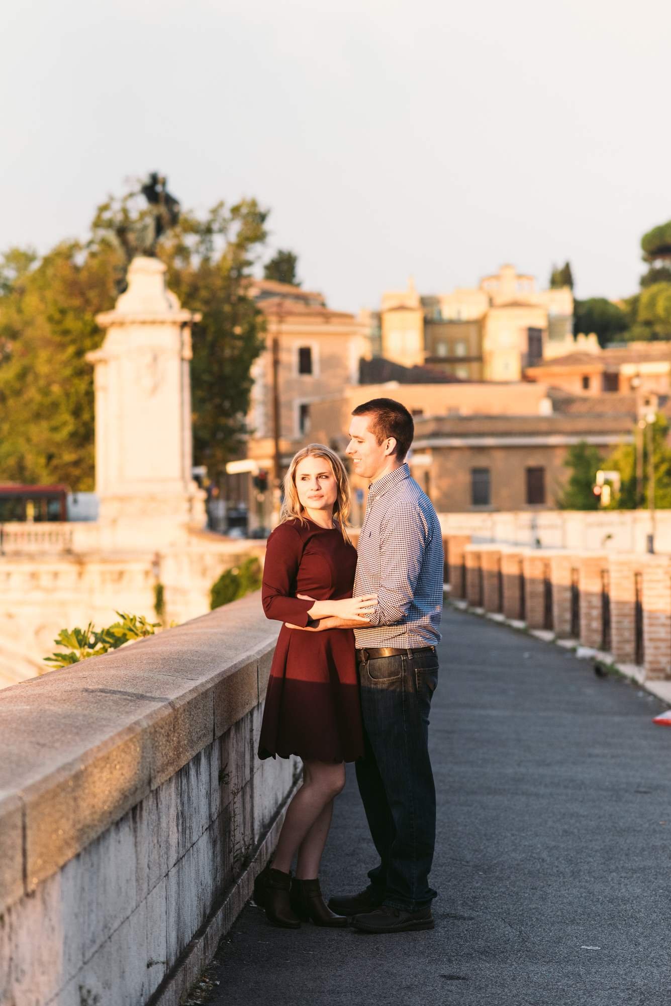 A couple on the bridge by the Tiber at sunrise