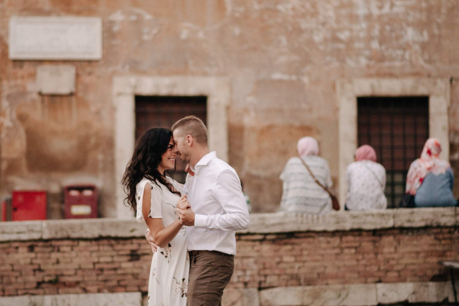 A couple kissing in a small piazza