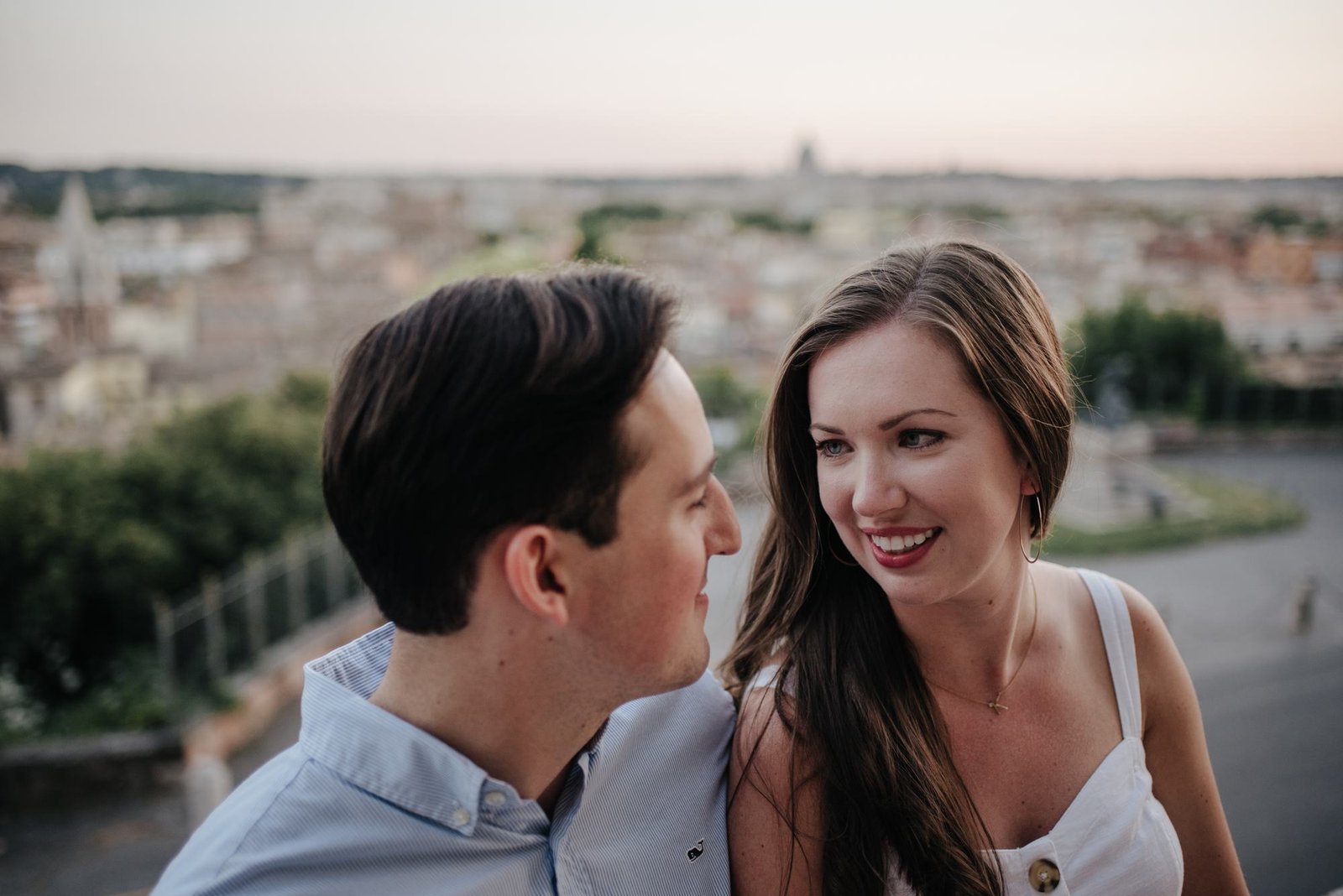 A couple laughing with the city behind